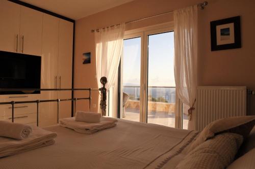 a bedroom with a bed and a sliding glass door at Villa Darymine in Skala Kefalonias