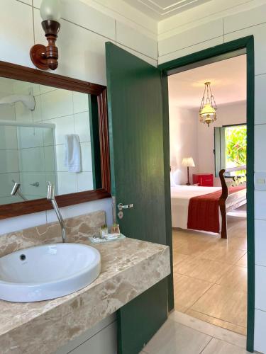 a bathroom with a sink and a room with a bed at Pousada Rio de Contas in Rio de Contas