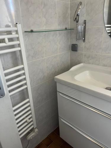 une salle de bain avec un lavabo blanc et une douche dans l'établissement Maison entière avec deux chambres et un jardin Dans résidence avec piscine et parking privé Proche de la mer et de la marina Au calme, à Saint Cyprien Plage
