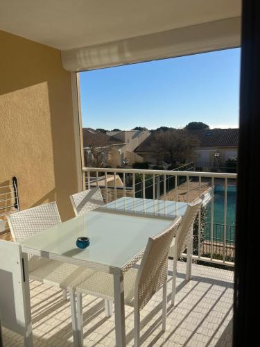 une table et des chaises sur un balcon avec vue sur l'océan dans l'établissement Appartement t2, à Fleury