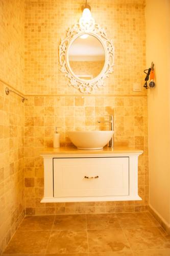 a bathroom with a sink and a mirror at Selin Hotel in Alaçatı