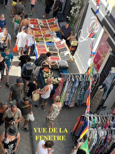 an overhead view of a crowd of people at a market at Charmant studio en centre-ville de L'Isle-sur-la-Sorgue in LʼIsle-sur-la-Sorgue