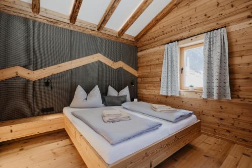 a bedroom with a bed in a wooden room at Chalet BRUNNHÄUSL in Hüttschlag