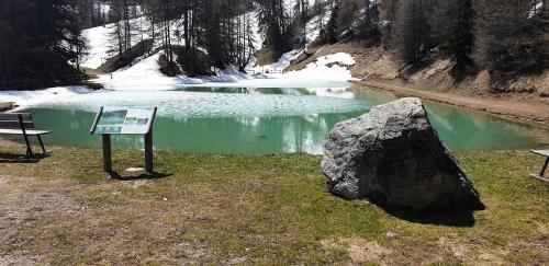a sign and a rock in front of a pond at Résidence Plagne Lauze - maeva Home - Studio 4 Personnes - Sélection MAE-4434 in Mâcot La Plagne