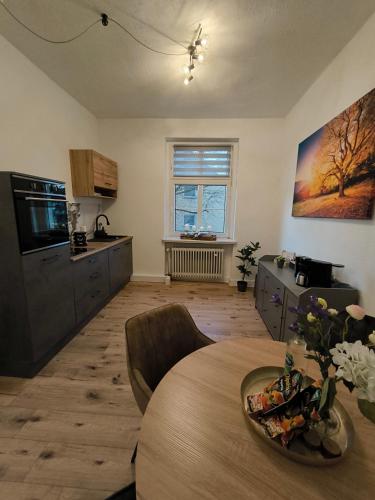 a living room with a table and a kitchen at Villa Baumhaus Apartments in Hamm