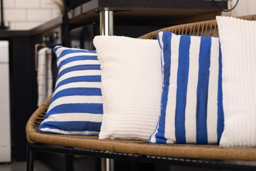 three blue and white pillows on a wicker chair at Studio 5A Willow Brook in Bedworth