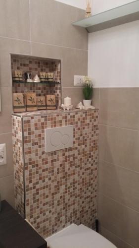 a bathroom with a toilet and a tiled wall at Civico 3 in Portofino