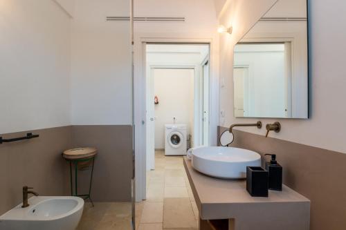 a bathroom with a tub and a sink and a mirror at Trulli di Mezza in Cisternino