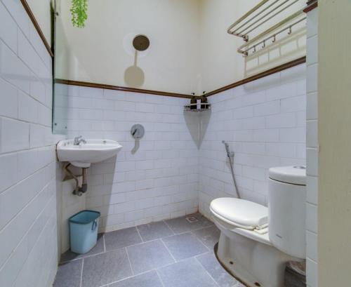 a bathroom with a toilet and a sink at Escotel Casa de Luga in Jakarta