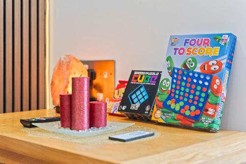 a table with a box of four to score and a book at Desi Suite, Free Parking, Balcony in Leicester