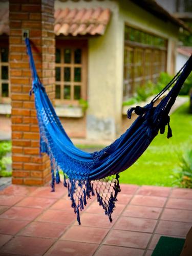 a blue hammock in front of a house at Re-Canto dos Pássaros - Mendes in Mendes