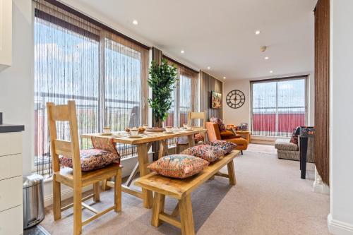 a dining room with a table and chairs and windows at Desi Suite, Free Parking, Balcony in Leicester