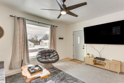 a living room with a flat screen tv and a chair at 3 Mi to Downtown Youngstown Updated Apartment in Youngstown