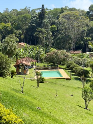 a swimming pool in a grassy yard with trees at Re-Canto dos Pássaros - Mendes in Mendes