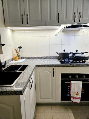 a kitchen with white cabinets and a stove top oven at Entire Space T3 Centralidade do Kilamba, Luanda in Luanda