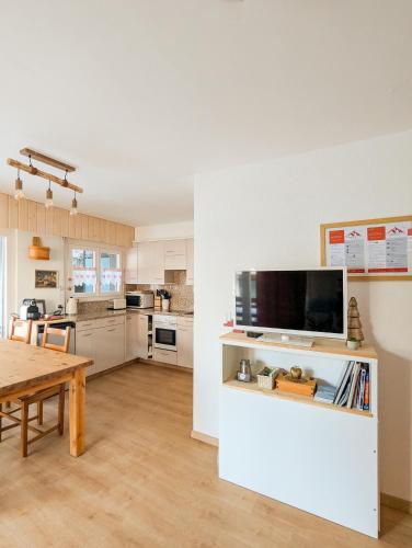 a living room with a table and a kitchen at Cosy Centered with Garden and View in Veysonnaz in Veysonnaz