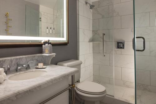 a bathroom with a toilet sink and a shower at Hotel Roanoke & Conference Center, Curio Collection by Hilton in Roanoke