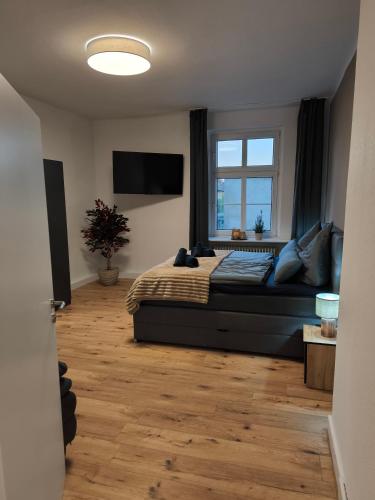 a bedroom with a bed and a window at Villa Baumhaus Apartments in Hamm