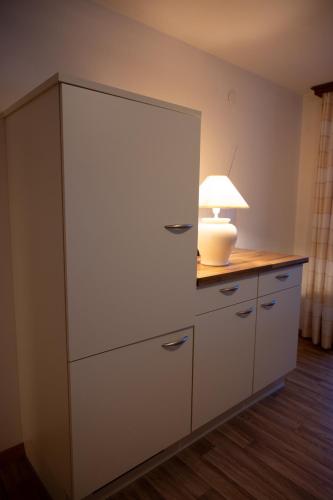 a white cabinet with a lamp on top of it at Ferienappartements Schrattengut in Abtenau