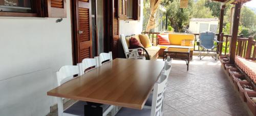 Una mesa y sillas de madera en un balcón. en Sea Esta Holiday Home, en Nea Skioni