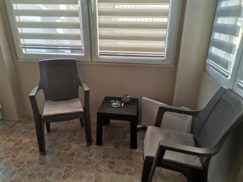 a room with two chairs and a table and a window at Apartman Meridian in Zaječar