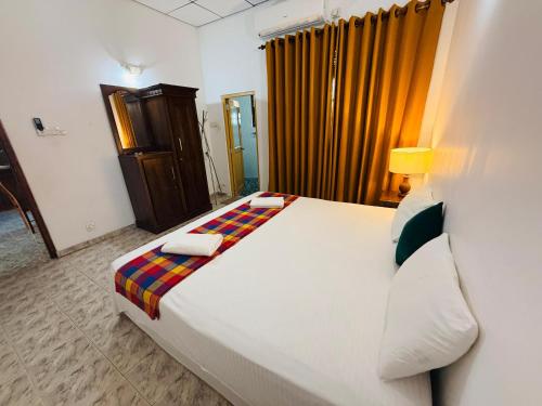 a bedroom with a large white bed in a room at Cinnamon Walauwaa in Piliyandala