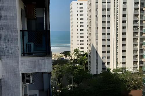 a view of the beach from between two buildings at Paraíso com piscina: Pitangueiras Lazer Completo in Guarujá