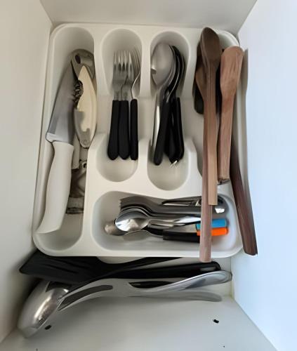 a drawer full of utensils in a refrigerator at Paraíso com piscina: Pitangueiras Lazer Completo in Guarujá