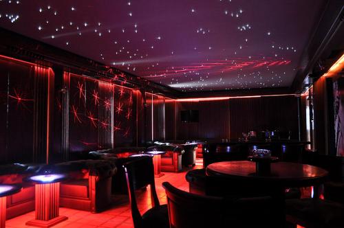 a dining room with tables and chairs and red lighting at Hotel Bozhentsi in Chernevtsi