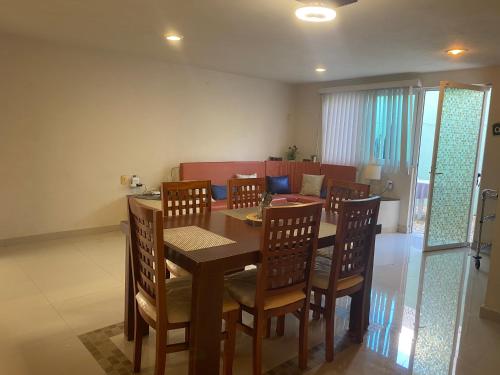 a dining room with a wooden table and chairs at Casa cocal in Cancún