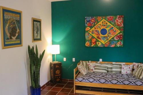 a living room with a couch and a painting on the wall at Sobrado da Casa Azul - Penedo in Itatiaia