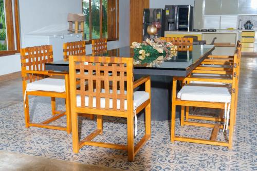a dining room table with four chairs and a glass top at Hacienda San Nicolas -Pto Boyaca in Puerto Triunfo
