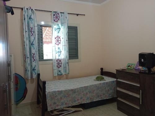 a bedroom with a bed and a dresser and a window at Cantinho da Paz in Capela do Alto