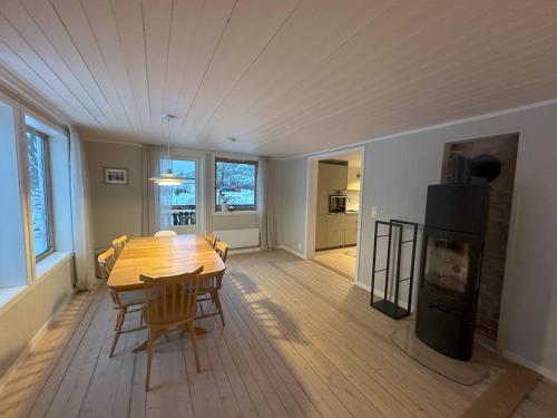 a dining room with a wooden table and a fireplace at Villa Mårsund in Bø