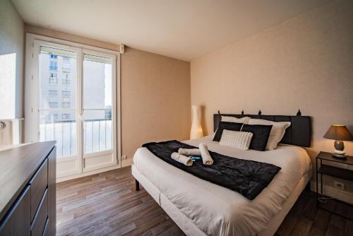 Un dormitorio con una cama y una ventana grande. en Le Châteaubriand - Parking - Netflix, en Tours