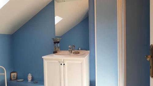 a bathroom with a sink and a blue wall at Gîte de France à Bonnefond 3 épis - Gîte de France 6 personnes MAE-9754 in Bonnefond