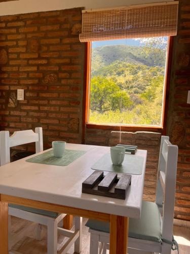 a table and chairs with a table and a window at Los Jilgueros in Los Hornillos