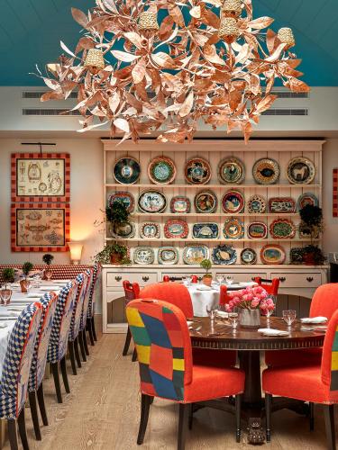a dining room with a table and chairs and a chandelier at Warren Street Hotel in New York