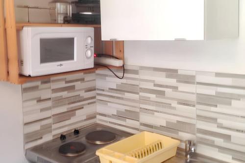 une cuisine avec un micro-ondes et une cuisinière dans l'établissement Studio cosy à Villarembert avec vue montagne - 14,5 m², à Villarembert