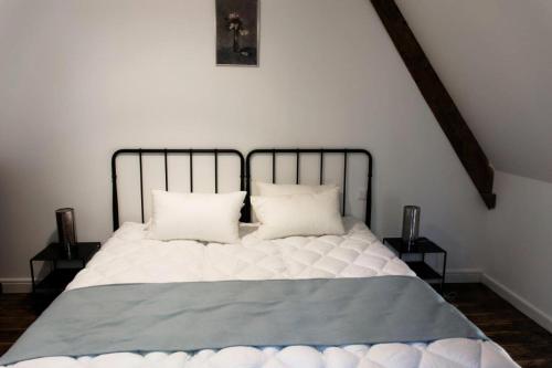 a bed with two pillows on it in a room at Gîte de France Belleviste 3 épis - Gîte de France 10 personnes MAE-1521 in Queyssac-les-Vignes
