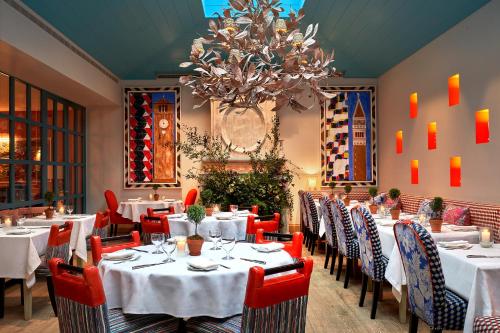 a restaurant with white tables and chairs and a chandelier at Warren Street Hotel in New York