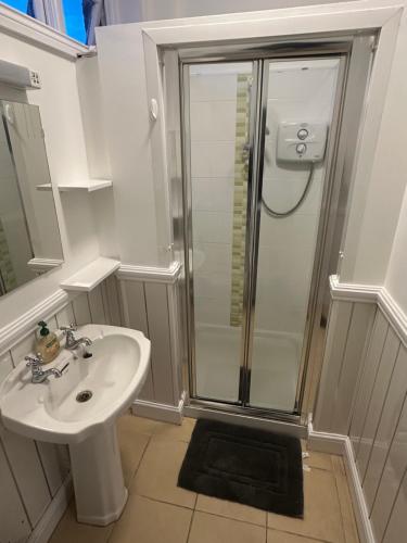 a white bathroom with a shower and a sink at 2-Bedroom Apartment-Dublin city centre in Dublin