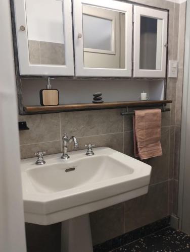 a bathroom with a white sink and two mirrors at Alquileres Allen in Allen