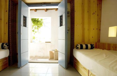 a bedroom with two beds and an open door at BORGO PETELIA, Casa Fazio, Antica piccola casa con loggia e scala esterna in Strongoli