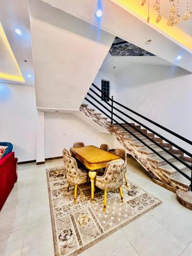 a dining room with a table and chairs and stairs at الكنجي مريوط in King Mariout