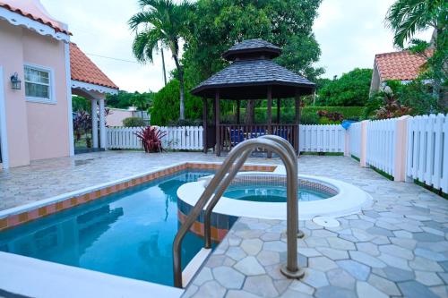 a swimming pool with a gazebo in a yard at Iyanola Tee Joys Villa in Gros Islet