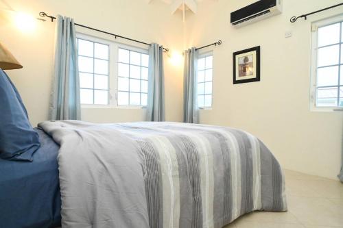 a bedroom with a bed with a blanket on it at Iyanola Tee Joys Villa in Gros Islet