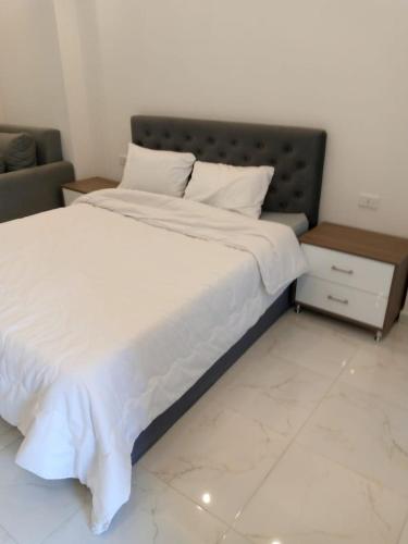 a bedroom with a large bed with white sheets at الغردقه in Hurghada