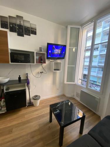 un salon avec une table basse et une télévision à écran plat dans l'établissement SMART STUDIO, à Cannes