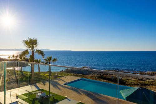 a view of the ocean from the balcony of a house at Villa Stella Sunset in Nea Dimmata